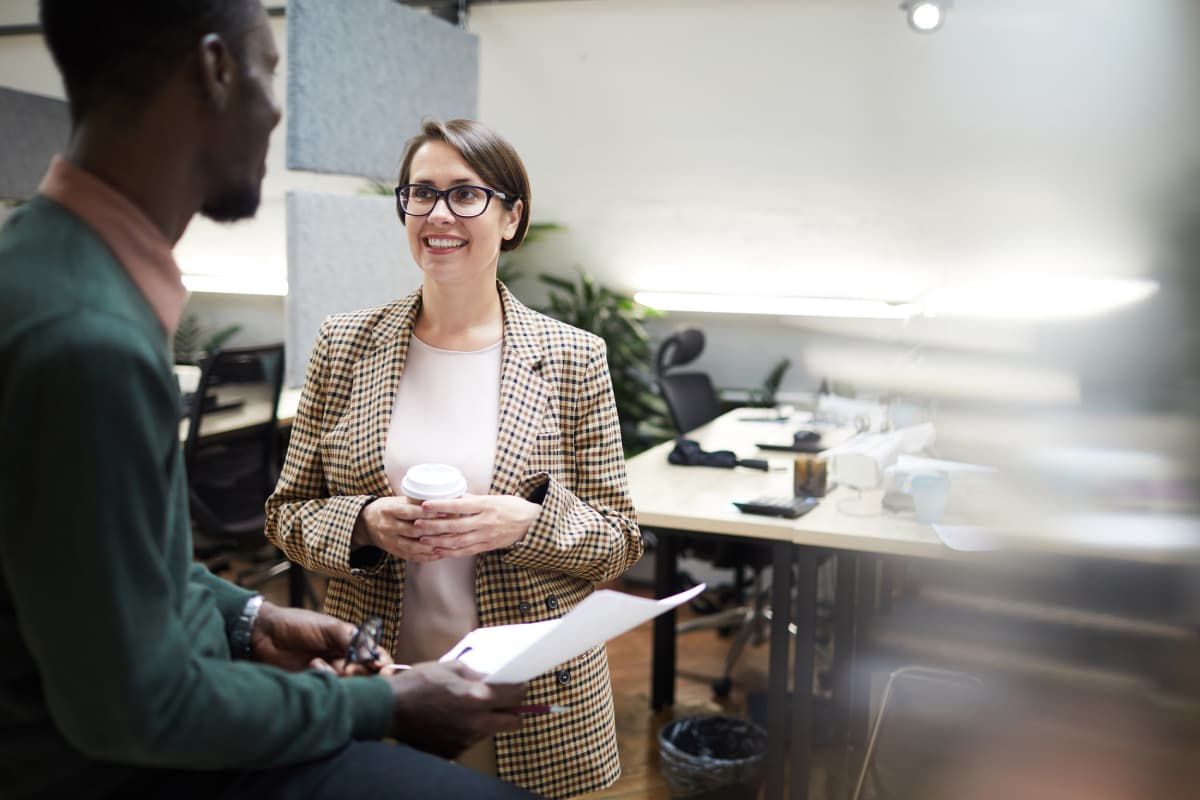 Smiling business manager talking to employee