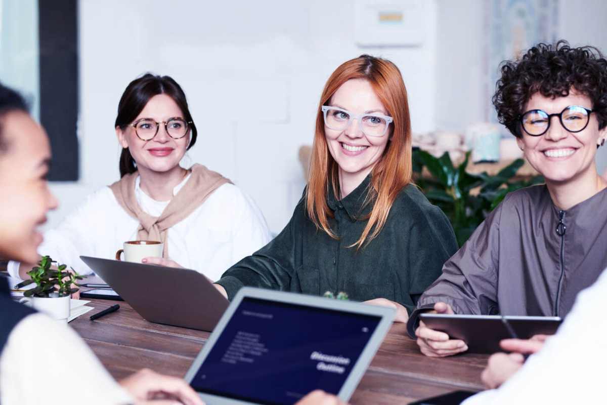 Group of smiling people working on tablets