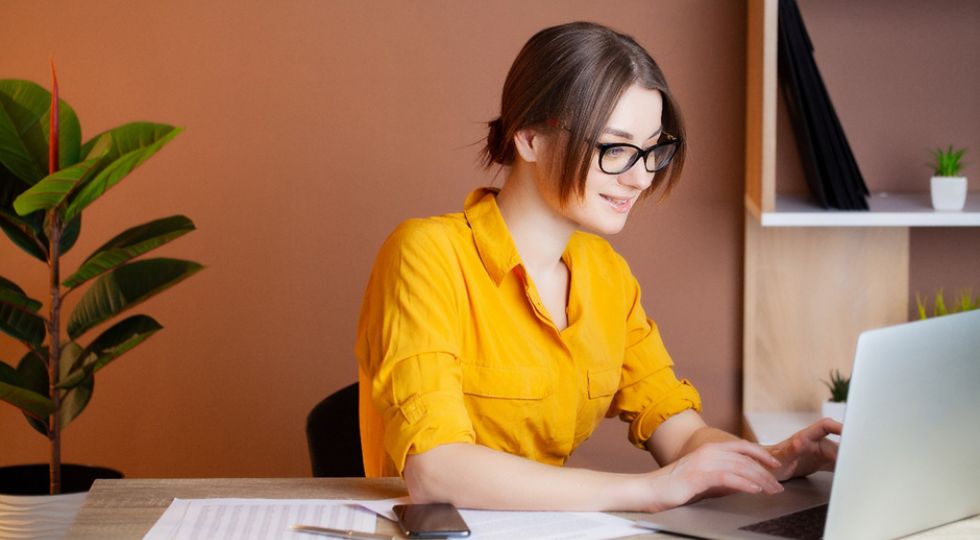 Woman in yellow blouse on laptop
